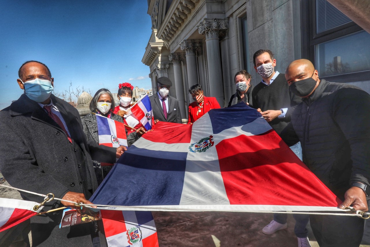 Dominican Flag raising ceremony. Mayor Fulop is pictured with several others hold the flag before it is raised.