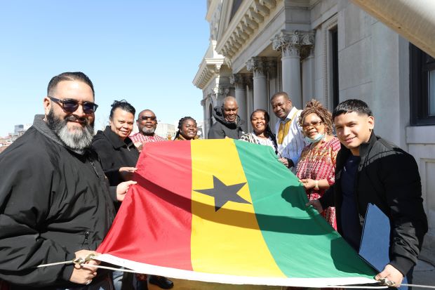 Attendees holding the Ghana flag on the City Hall balcony.