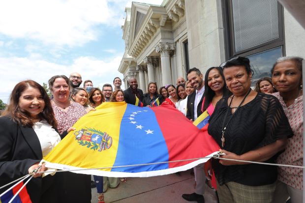 The group picture of the Venezuela flag raising on the balcony at City Hall.